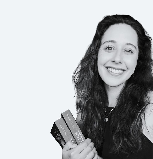 Erica Gallegos smiling, holding paperbacks of her books